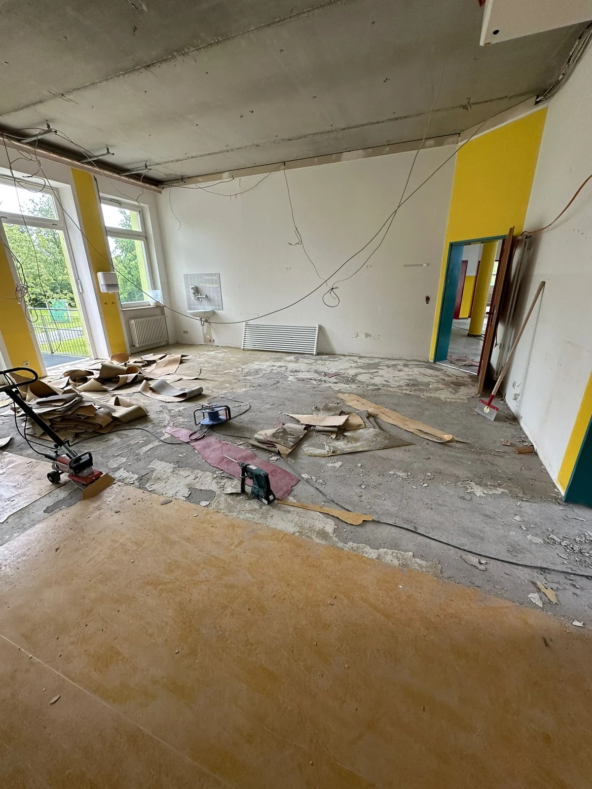 Saal während der Renovierung mit freigelegtem Boden und offener Decke